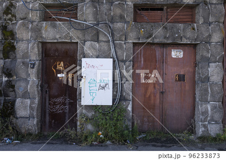 The metal doors of the entrance to the transformer in the wall of red brick 96233873