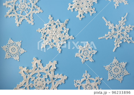 Top view of handmade white crochet snowflakes on blue background. Merry Christmas and happy new year concept.. 96233896