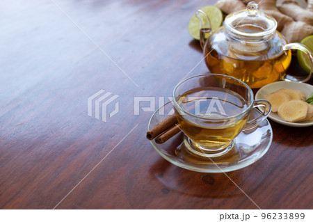a cup of tea with ginger root, lime, cinnamon and teapot on white background. Health drink concept. a cup of tea with ginger root, lime, cinnamon and teapot on white background. Health drink concept. 96233899