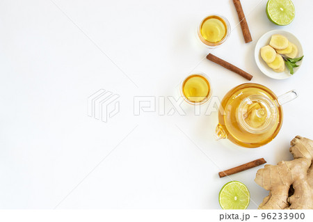 Top view of a cup of tea with ginger root, lime, cinnamon and teapot on white background. Health drink concept. 96233900