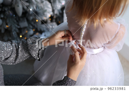 New Year, mom dresses her daughter. 2022 New Year, mom dresses her daughter. 2022 96233981
