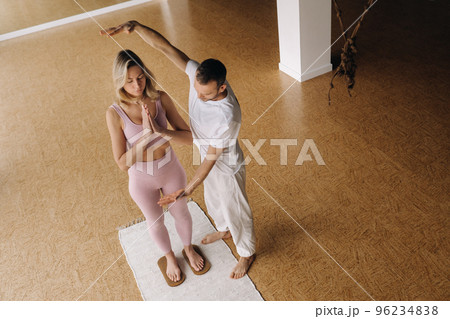 a man and a woman do yoga on boards with nails in the gym a man and a woman do yoga on boards with nails in the gym 96234838