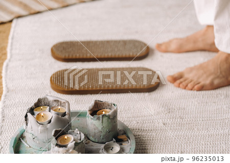 The man's feet are next to boards with nails. Yoga classes 96235013