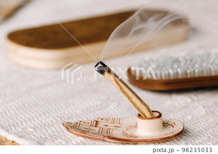 A smoking Palo Santo stick and boards with nails for yoga classes 96235033