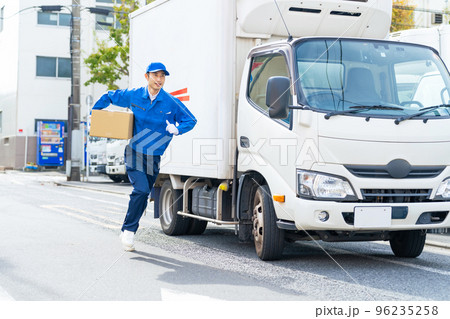 荷物を持って走るセールスドライバー　配達員 96235258