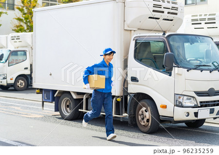 荷物を持って走るセールスドライバー　配達員 96235259
