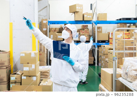 白衣を着て倉庫を点検する作業員 96235288
