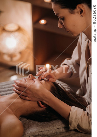A cosmetologist girl does a facial and neck massage to a girl in the office for skin elasticity A cosmetologist girl does a facial and neck massage to a girl in the office for skin elasticity 96236030