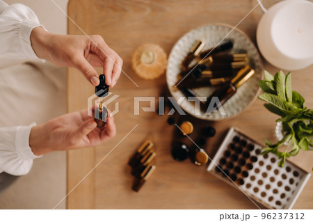 Close-up of female hands holding a bottle of essential oil, Aromatherapy 96237312