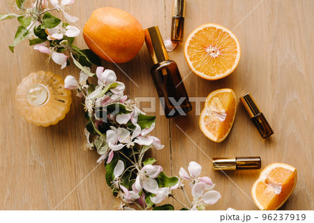 Essential oil in bottles with the aroma of apple and mint flowers lying on a wooden surface Essential oil in bottles with the aroma of apple and mint flowers lying on a wooden surface 96237919