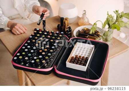 Close-up of female hands holding a bottle of essential oil, Aromatherapy 96238115