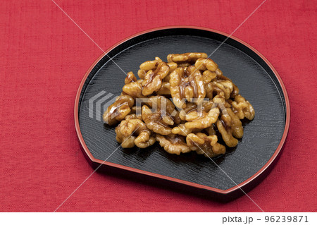 おせち料理その14-02_黒皿のクルミの甘露煮_背景赤 96239871