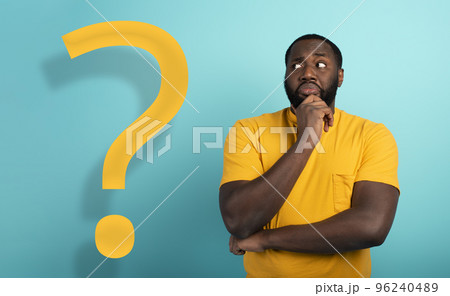 Confused and pensive expression of a boy with many questions . cyan colored background Confused and pensive expression of a boy with many questions . cyan colored background 96240489