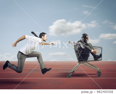 Businessman runs fast driving a cart during a competition 96240508