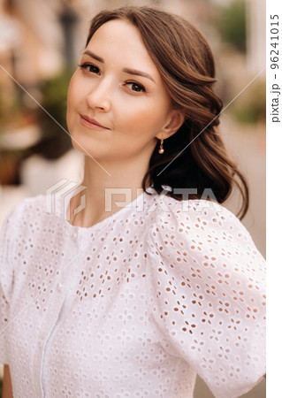 A beautiful woman in a white dress at sunset in the city. Evening street photography A beautiful woman in a white dress at sunset in the city. Evening street photography 96241015