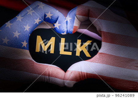Hands of afro-american person in glove with colors of American Flag. Gesture of heart. Black background with MLK. Happy Martin Luther King Day concept 96241089