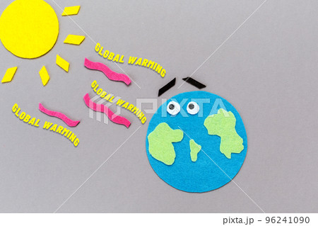 Environment disaster. The planet earth and the sun are carved out of felt. Gray background. Flat lay. The concept of global warming Environment disaster. The planet earth and the sun are carved out of felt. Gray background. Flat lay. The concept of global warming 96241090