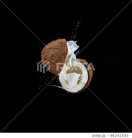 Cracked Coconut with milk splash flying in the air, isolated on black. Cracked Coconut with milk splash flying in the air, isolated on black. 96242583