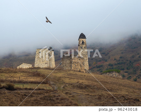 Battle towers Erzi in the Jeyrah gorge. Medieval tower complex Erzi, one of the largest medieval castle-type tower villages, located on the extremity of the mountain range in Ingushetia, Russia. Battle towers Erzi in the Jeyrah gorge. Medieval tower complex Erzi, one of the largest medieval castle-type tower villages, located on the extremity of the mountain range in Ingushetia, Russia. 96243018