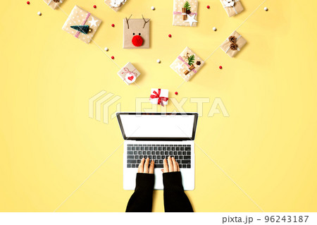 Person using a laptop computer with Christmas gift boxes Person using a laptop computer with Christmas gift boxes 96243187