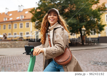 Close up portrait of young woman with electric scooter at the city Close up portrait of young woman with electric scooter at the city 96243192