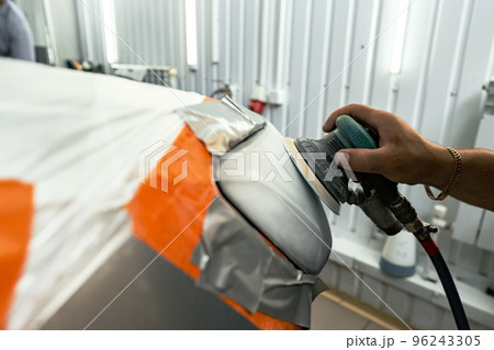 Close up of car cleaner polishing headlight with polish machine Close up of car cleaner polishing headlight with polish machine 96243305