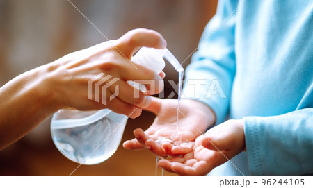 Hands with sanitizer gel. Mother and child using sanitize soap for hand coronavirus protection. 96244105