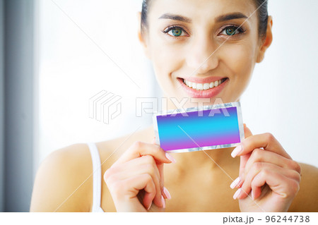 Teeth Whitening. Beautiful Smiling Woman Holding Whitening Strip. High Resolution Image Teeth Whitening. Beautiful Smiling Woman Holding Whitening Strip. High Resolution Image 96244738