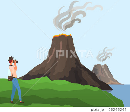 Man with camera takes photo of volcanic landscape. Photographer looking at dormant volcano 96246245