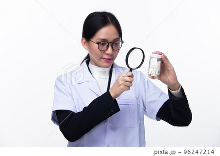 Half body face 30s 40s Asian Woman Pharmacist Doctor, wear formal lab Coat. Smile Hospital female hold magnifying search investigate find out drug pill detail over white background isolated Half body face 30s 40s Asian Woman Pharmacist Doctor, wear formal lab Coat. Smile Hospital female hold magnifying search investigate find out drug pill detail over white background isolated 96247214