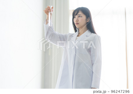 試験管を持つ白衣の女性 96247296