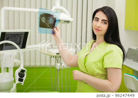 Female dentist in dental office examining patient teeth 96247449