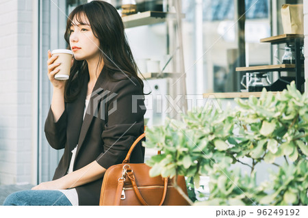 屋外でコーヒーを飲む女性 96249192