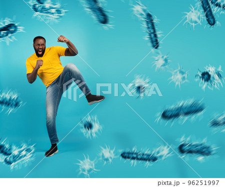 African-American man fighting with bare hands against viruses and bacteria on cyan background 96251997