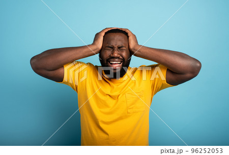 Sad and desperate expression of a boy who is scared to catch the covid-19 coronavirus. Cyan background. 96252053