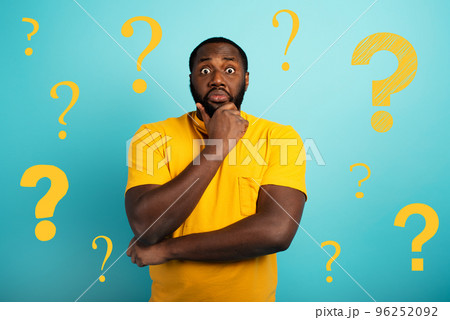Confuse and pensive expression of a boy with many questions . cyan colored background Confuse and pensive expression of a boy with many questions . cyan colored background 96252092