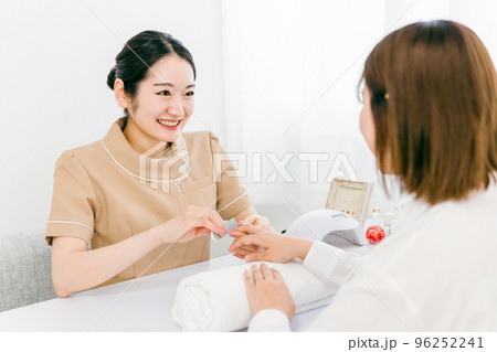 ネイルサロンでサンディングするネイリストと施術を受ける日本人女性 ネイルサロンでサンディングするネイリストと施術を受ける日本人女性 96252241