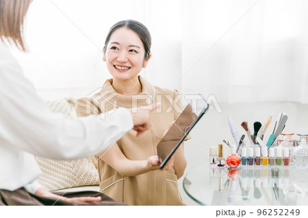 ネイルサロンでタブレットを使ってネイリストにカウンセリングを受ける日本人女性 ネイルサロンでタブレットを使ってネイリストにカウンセリングを受ける日本人女性 96252249