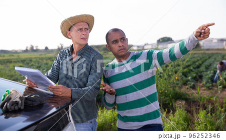 Farmer signs the documents for the delivery of the goods to farm field 96252346