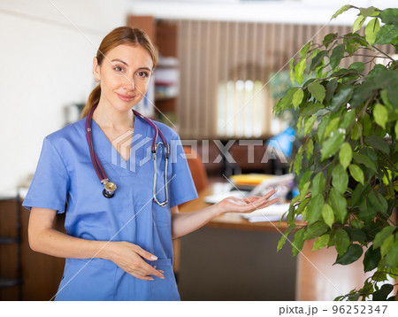 Female doctor in surgical scrubs standing in hall 96252347