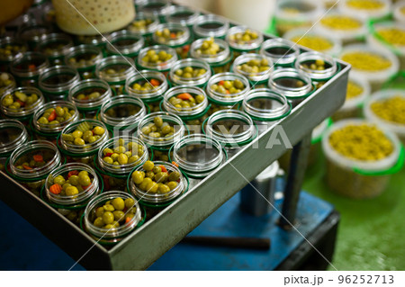 Filling of glass jars with pickled olives Filling of glass jars with pickled olives 96252713