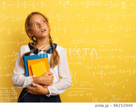 Young student is with shocked expression and think about complex exercises. Yellow background 96252940