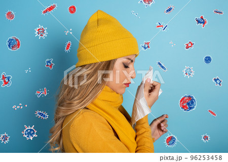 Girl caught a cold and is surrounded by viruses and bacteria. Studio on Cyan background 96253458