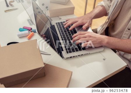 Seamstress works to new clothes ordered by internet client 96253478