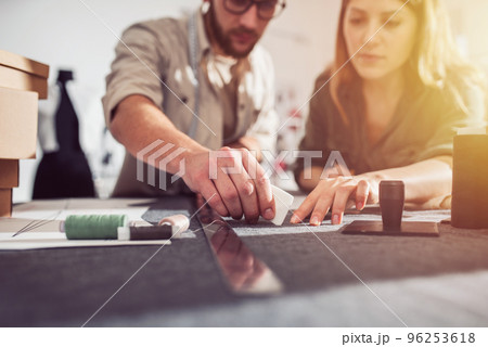 Seamstresses team ready to ship package to client with new clothes Seamstresses team ready to ship package to client with new clothes 96253618