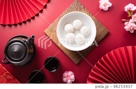 Tang Yuan(sweet dumplings balls), a traditional cuisine for Mid-autumn, Dongzhi (winter solstice ) and Chinese new year with plum flower and tea on red background. Tang Yuan(sweet dumplings balls), a traditional cuisine for Mid-autumn, Dongzhi (winter solstice ) and Chinese new year with plum flower and tea on red background. 96253937