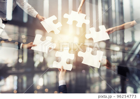 Teamwork of partners. Concept of integration and startup with puzzle pieces. Double exposure 96254773