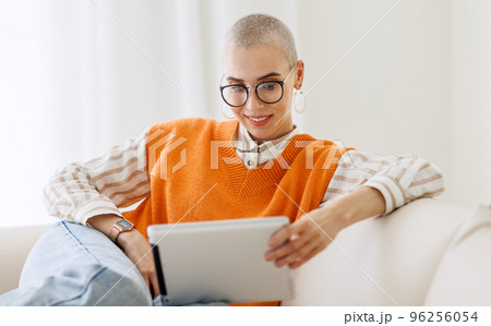 Beautiful woman freelancer with very short hair working at tablet at home Beautiful woman freelancer with very short hair working at tablet at home 96256054