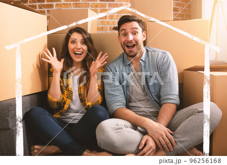 Happy couple have found a new home and they need to arrange all the packages. Concept of success, change, positivity and future Happy couple have found a new home and they need to arrange all the packages. Concept of success, change, positivity and future 96256168