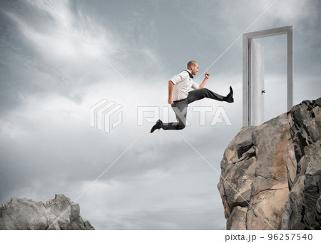 Businessman jumping over the mountains to reach a door 96257540